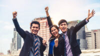 Businessmen and businesswoman celebrate success.